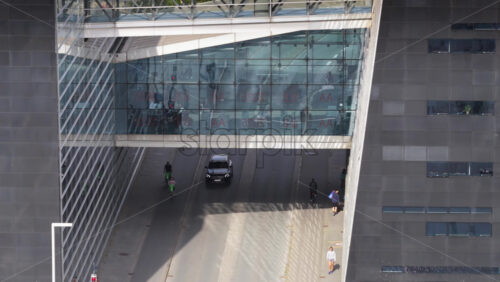 Copenhagen, Denmark – August 4, 2025: Aerial drone view of modern architecture at Copenhagen Business School with skybridge connecting glass buildings over a city street - Starpik Stock