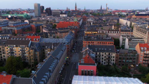 Copenhagen, Denmark – August 4, 2025: Aerial drone view of red-roofed buildings and the iconic Copenhagen City Hall tower rising in the distance - Starpik Stock