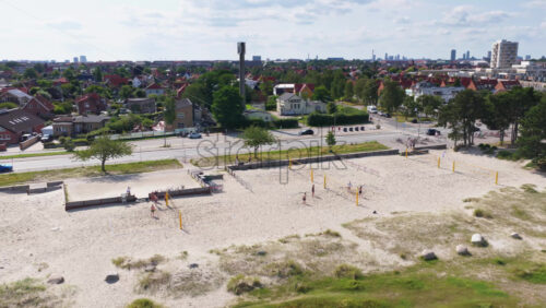 Copenhagen, Denmark – August 4, 2025: Aerial drone view of sandy volleyball courts at Amager Strand, with players enjoying a sunny day by the beach - Starpik Stock