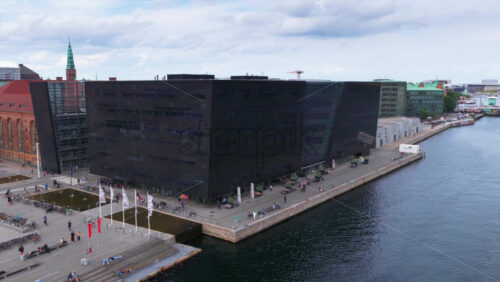 Copenhagen, Denmark – August 4, 2025: Aerial drone view of the modern glass extension of the Royal Danish Library, overlooking Copenhagen’s waterfront - Starpik Stock