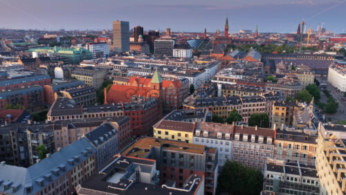 Copenhagen, Denmark – August 4, 2025: Aerial drone view over Copenhagen’s city center with historic rooftops, the Church of the Holy Ghost, and Tivoli Gardens in the distance - Starpik Stock