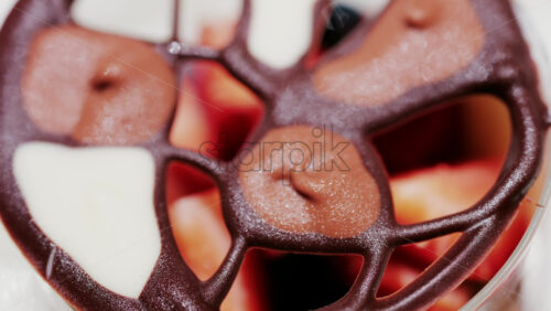 Elegant dessert in a glass topped with fresh strawberries, blueberries, and a chocolate lattice decoration - Starpik Stock