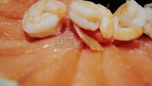 Fresh seafood platter with smoked salmon slices, shrimp, olives, and pate served with lemon and dill garnish - Starpik Stock