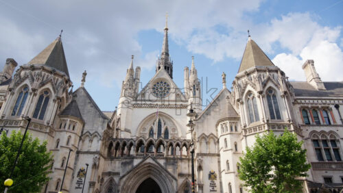 Front view of the main entrance of the Royal Courts of Justice in London, England under a clear blue sky - Starpik Stock