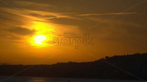 Golden sunset over the Mediterranean Sea with silhouettes of palm trees and people relaxing on the beach in Nice, France - Starpik Stock