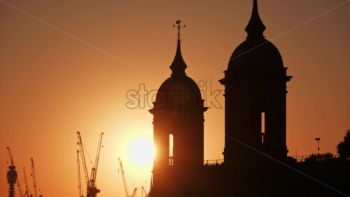 Golden sunset silhouettes of a historic towers of Cannon Street Railway Bridge in central London, England - Starpik Stock