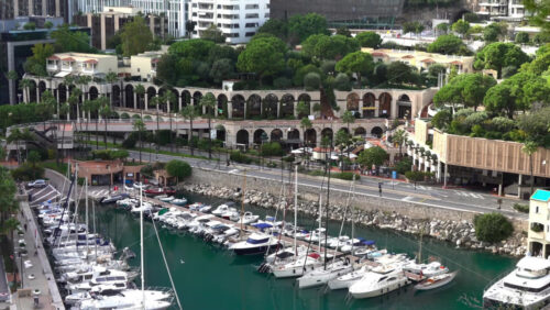 High-angle view of Port de Fontvieille in Monaco, showcasing colorful buildings, luxury yachts, and the surrounding mountainous landscape - Starpik Stock