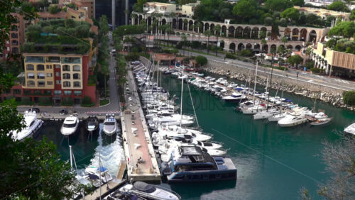 High-angle view of Port de Fontvieille in Monaco, showcasing colorful buildings, luxury yachts, and the surrounding mountainous landscape - Starpik Stock
