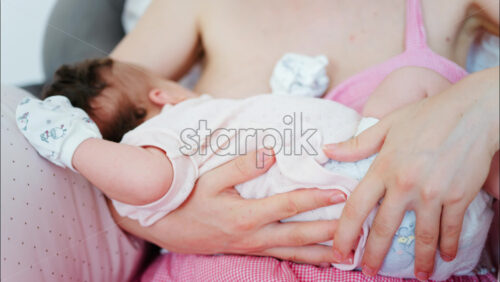 Intimate close up of a mother breastfeeding her baby - Starpik Stock