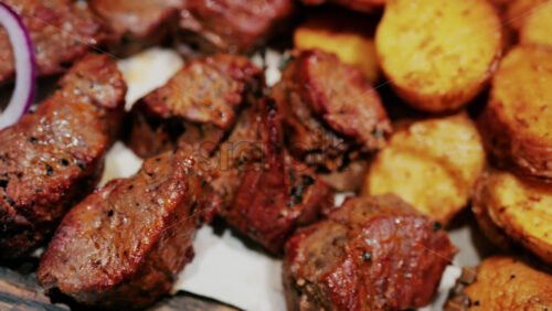 Juicy grilled meat served with golden roasted potatoes, tomatoes, mushrooms, and sauce - Starpik Stock