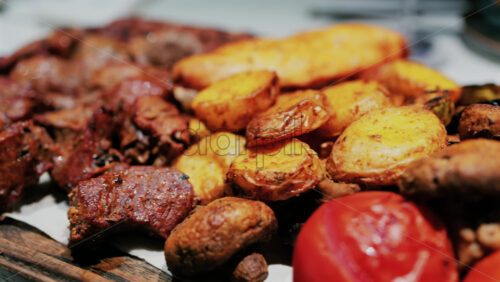 Juicy grilled meat served with golden roasted potatoes, tomatoes, mushrooms, and sauce - Starpik Stock