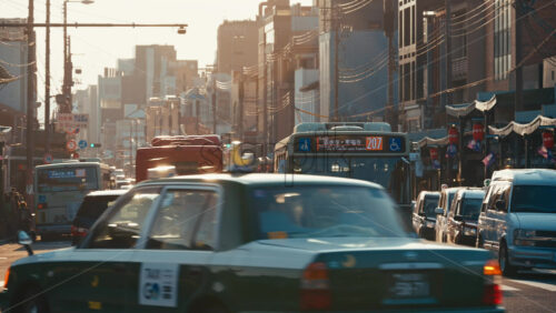 Kyoto, Japan – April 11, 2025: Cars and public transportation buses moving on the streets of the Gion area at sunset - Starpik Stock