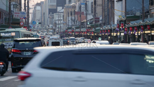 Kyoto, Japan – April 11, 2025: Cars and public transportation moving on the streets of the Gion area at sunset. Translation: “Street names” - Starpik Stock