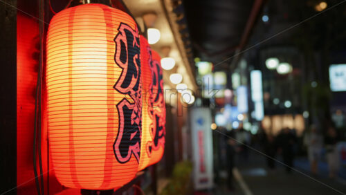 Kyoto, Japan – April 11, 2025: Close up of lighted red paper lanterns hanging on the street in Shinjuku City in the evening - Starpik Stock