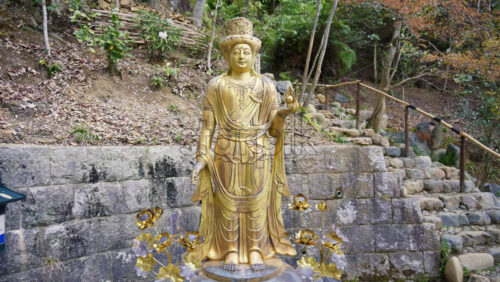Kyoto, Japan – April 11, 2025: Gold sculpture of Guanyin in the garden of the Otagi Nenbutsuji Temple - Starpik Stock