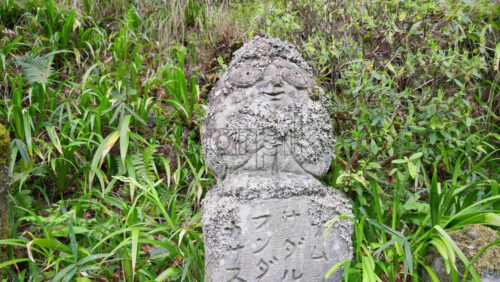 Kyoto, Japan – April 11, 2025: Moss-covered arhat statue covering the hillside around the temple grounds at the Otagi Nenbutsuji Temple. Translation: “Mandala of dharma” - Starpik Stock