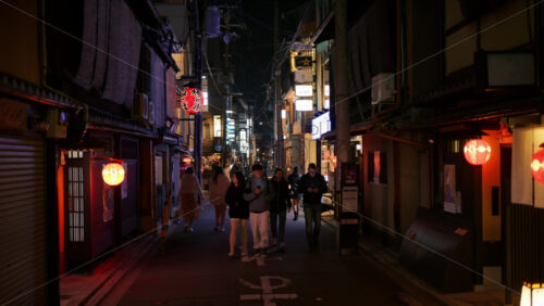 Kyoto, Japan – April 11, 2025: People walking on the streets of the Gion area in the evening. Translation: “Store names” - Starpik Stock