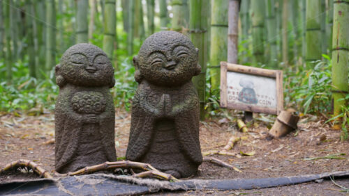 Kyoto, Japan – April 11, 2025: Stone Jizo statues standing side by side in the Arashiyama Bamboo Forest in Kyoto, Japan - Starpik Stock
