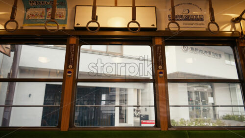 Kyoto, Japan – April 11, 2025: View of the city from the tram moving towards Arashiyama in daylight. Translation: “KK company space workshop” - Starpik Stock