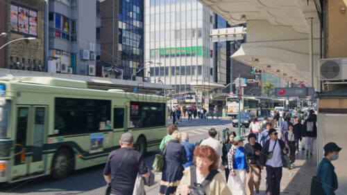 Kyoto, Japan – April 12, 2025: People and public transportation moving on the streets of the Gion area in daylight. Translation: “Store names” - Starpik Stock