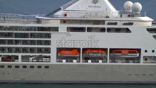 La Condamine, Monaco – July 4, 2025: Side view of a large cruise ship docked in Monaco, revealing multiple decks, balconies, and passengers enjoying ocean view - Starpik Stock
