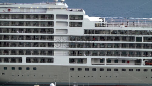 La Condamine, Monaco – July 4, 2025: Side view of a large cruise ship docked in Monaco, revealing multiple decks, balconies, and passengers enjoying ocean view - Starpik Stock
