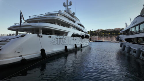 La Condamine, Monaco – July 8, 2025: Boats docked in Port Hercule with buildings on the background in the evening - Starpik Stock