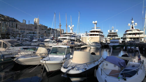 La Condamine, Monaco – July 8, 2025: Boats docked in Port Hercule with buildings on the background in the evening - Starpik Stock