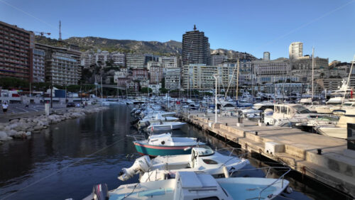 La Condamine, Monaco – July 8, 2025: Boats docked in Port Hercule with buildings on the background in the evening - Starpik Stock