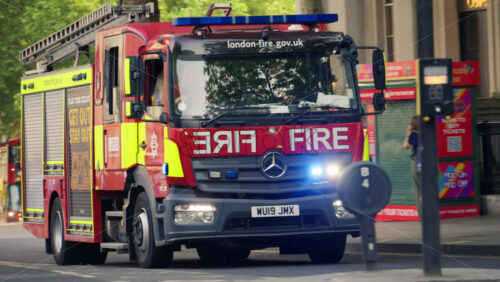 London, England – May 11, 2025: Fire truck driving with lights on through Charing Cross street - Starpik Stock