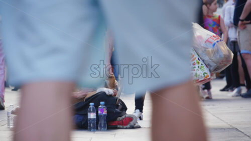 London, England – May 11, 2025: Homeless man sitting on the sidewalk of Piccadilly Circus with a dog while a woman offers money and pets the dog - Starpik Stock