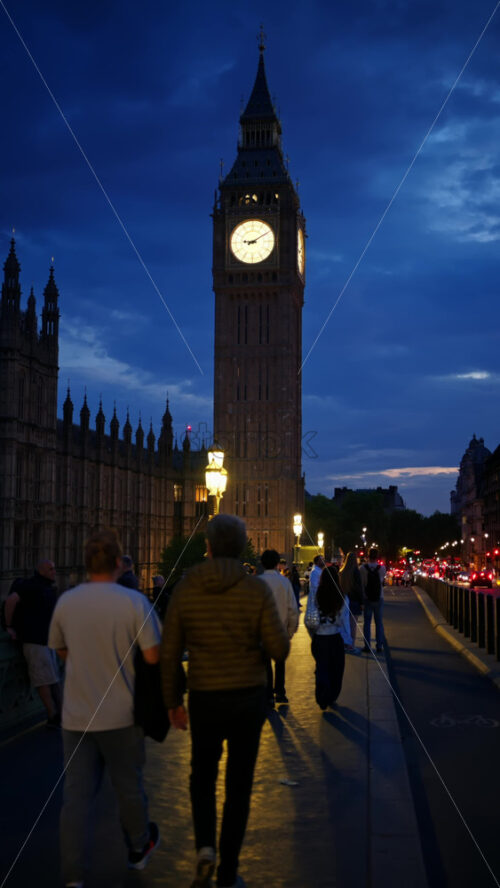 London, England – May 11, 2025: View of Big Ben illuminated at dusk with people walking in font of it. Vertical - Starpik Stock