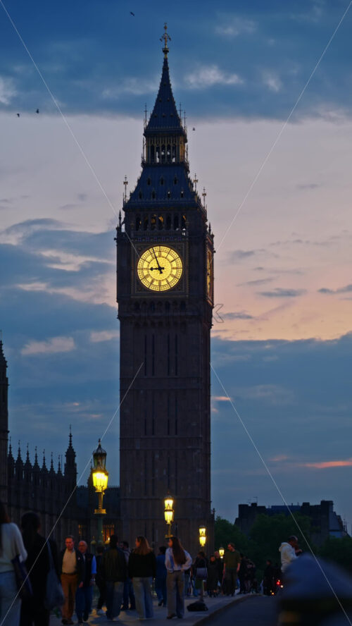London, England – May 11, 2025: View of Big Ben illuminated at dusk with people walking in font of it. Vertical - Starpik Stock