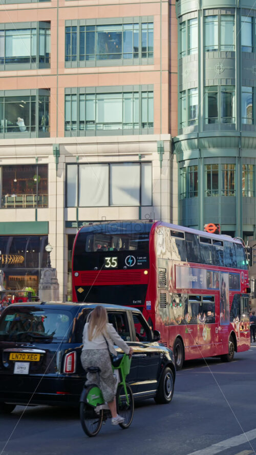 London, England – May 12, 2025: Busy Liverpool street with red buses, pedestrians and traditional city buildings. Vertical - Starpik Stock