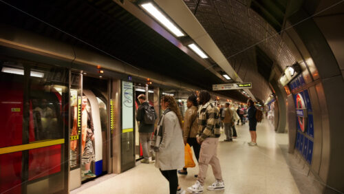 London, England – May 12, 2025: Commuters boarding an Underground train inside a modern tube station during the evening rush hour - Starpik Stock
