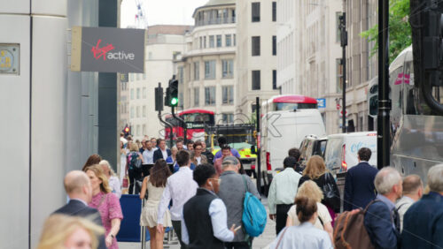 London, England – May 12, 2025: Crowded Cannon Street sidewalk filled with workers and commuters, with buses and traffic in the background - Starpik Stock