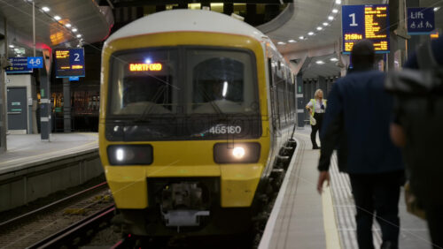 London, England – May 12, 2025: Passengers waiting and boarding at London Bridge train station platform under evening lights - Starpik Stock
