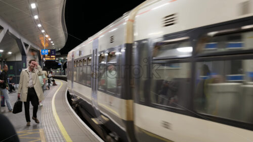 London, England – May 12, 2025: Passengers waiting and boarding at London Bridge train station platform under evening lights - Starpik Stock