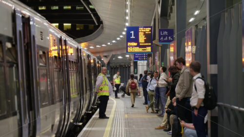 London, England – May 12, 2025: Passengers waiting and boarding at London Bridge train station platform under evening lights - Starpik Stock