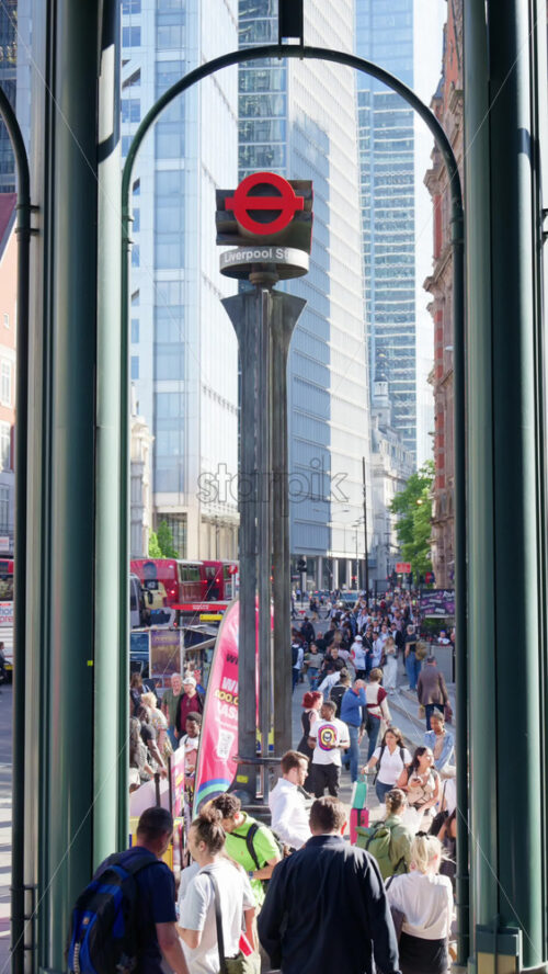 London, England – May 12, 2025: Red London Underground sign at Liverpool Street station, framed by modern city buildings. Vertical - Starpik Stock