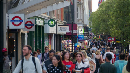 London, England – May 12, 2025: Slow motion video of busy Oxford Street packed with pedestrians, store signs, and underground entrances in daylight - Starpik Stock