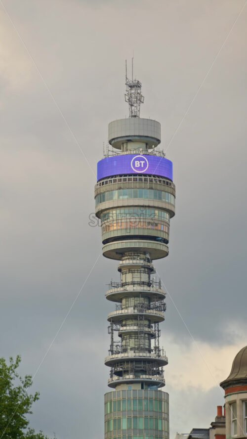 London, England – May 12, 2025: Tall BT Tower telecommunications building with clear skies and an airplane in the background. Vertical - Starpik Stock