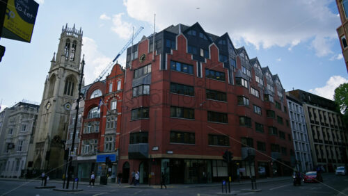 London, England – May 12, 2025: Time lapse of transportation moving through an urban corner of Fleet Street featuring a red-brick office building - Starpik Stock