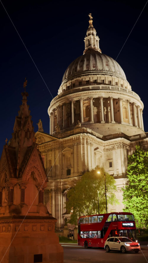 London, England – May 12, 2025: View of St. Paul’s Cathedral with cars moving along a busy street at night. Vertical - Starpik Stock