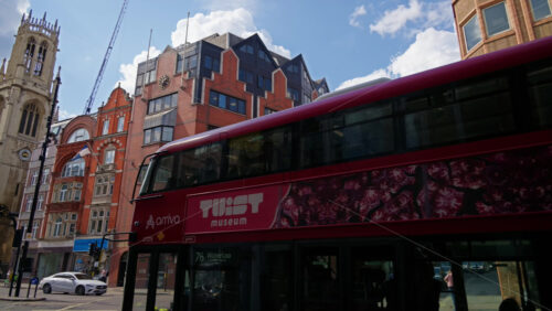 London, England – May 12, 2025: View of transportation moving through an urban corner of Fleet Street featuring a red-brick office building - Starpik Stock