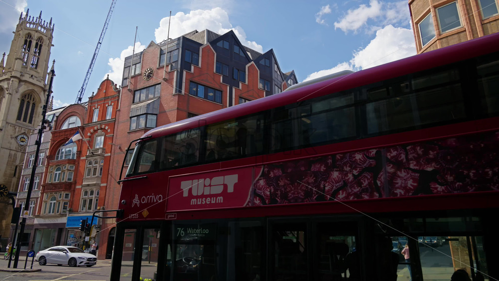 London, England – May 12, 2025: View of transportation moving through an urban corner of Fleet Street featuring a red-brick office building - Starpik Stock
