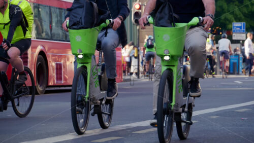 London, England – May 13, 2025: A group of cyclists commuting through the city near Liverpool Station on a sunny morning with glass buildings in the background - Starpik Stock