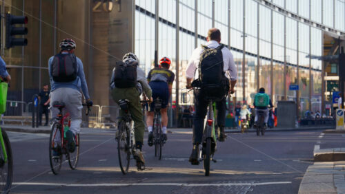 London, England – May 13, 2025: A group of cyclists commuting through the city on a sunny morning with glass buildings in the background - Starpik Stock