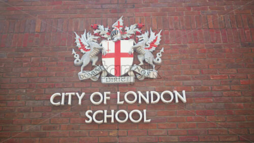 London, England – May 13, 2025: Close-up of the City of London School crest mounted on a red-brick wall in daylight - Starpik Stock