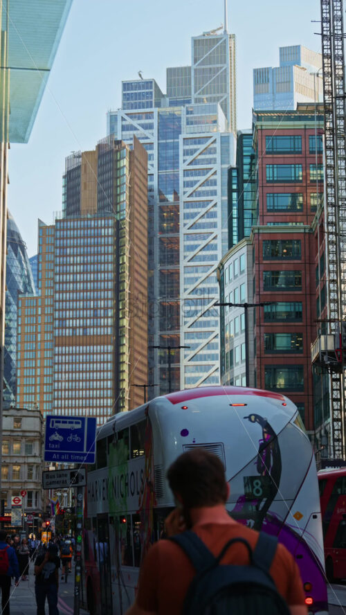 London, England – May 13, 2025: Modern glass skyscrapers of London’s financial district reflecting the blue sky next to historic architecture. Vertical - Starpik Stock
